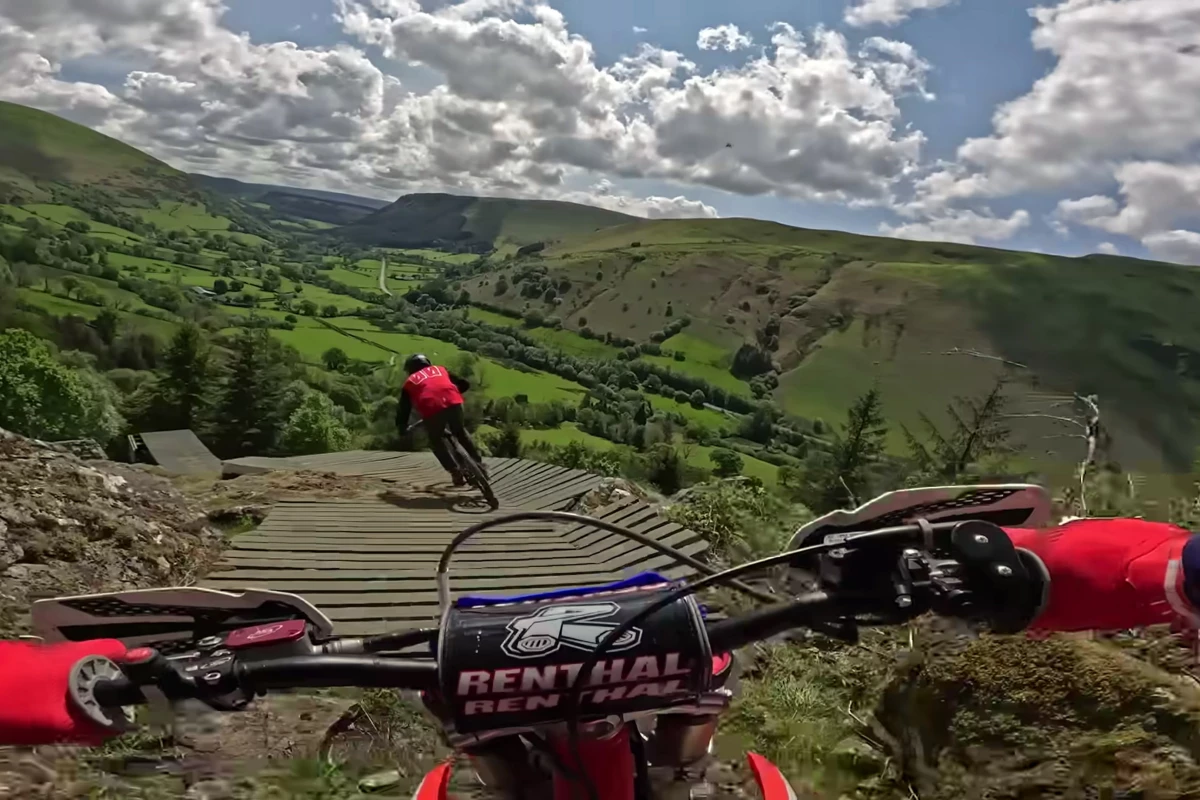 Johnny Walker rides behind the Red Bull VJ about to huck the road gap in which is probably the very first time pedal and motor have ever ridden together on Hardline