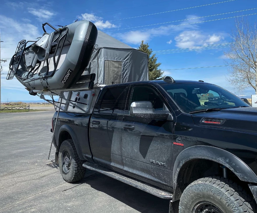Skinny Guy's prototype rack carries gear and tilts it out of the way for camper setup, no need to pull the gear off so long as it doesn't exceed the weight limit