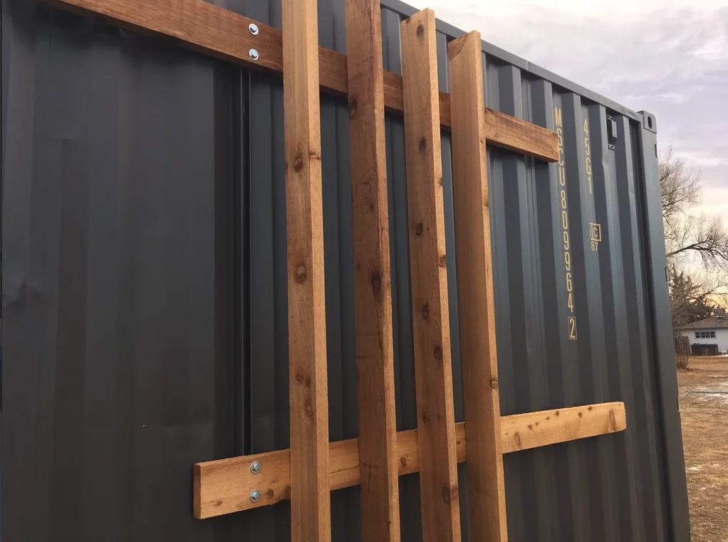 The exterior of the Intellectual Tiny Home has cedar shelving attached, which can be used to create a green wall