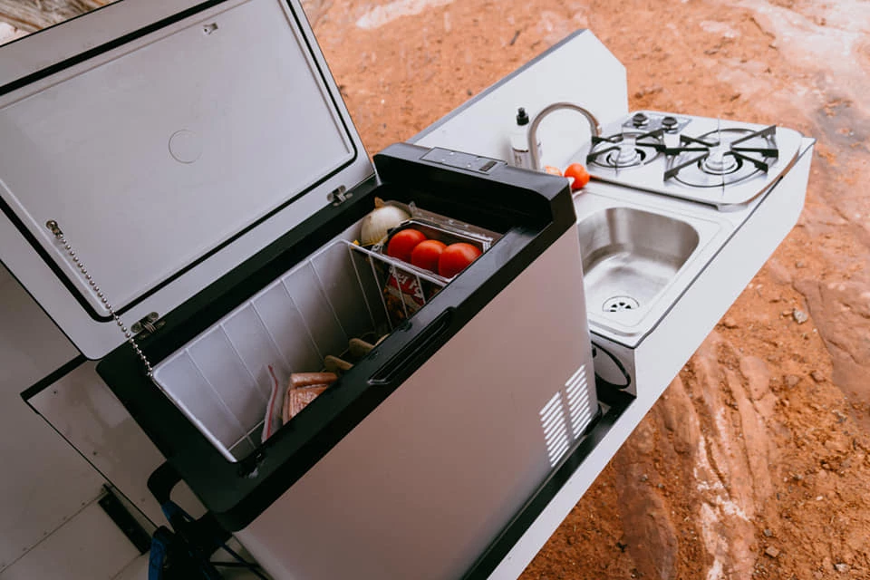 The swing-out kitchen arm holds all the functional equipment, leaving the interior free to work as a counter and/or campsite storage shelf