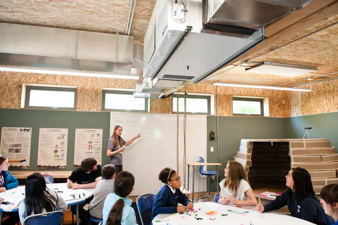 Inside, the classroom looks almost unfinished. The chipboard walls are visible, as are all the ducts, cables, conduits and structural supports, allowing the children to see firsthand how the building works