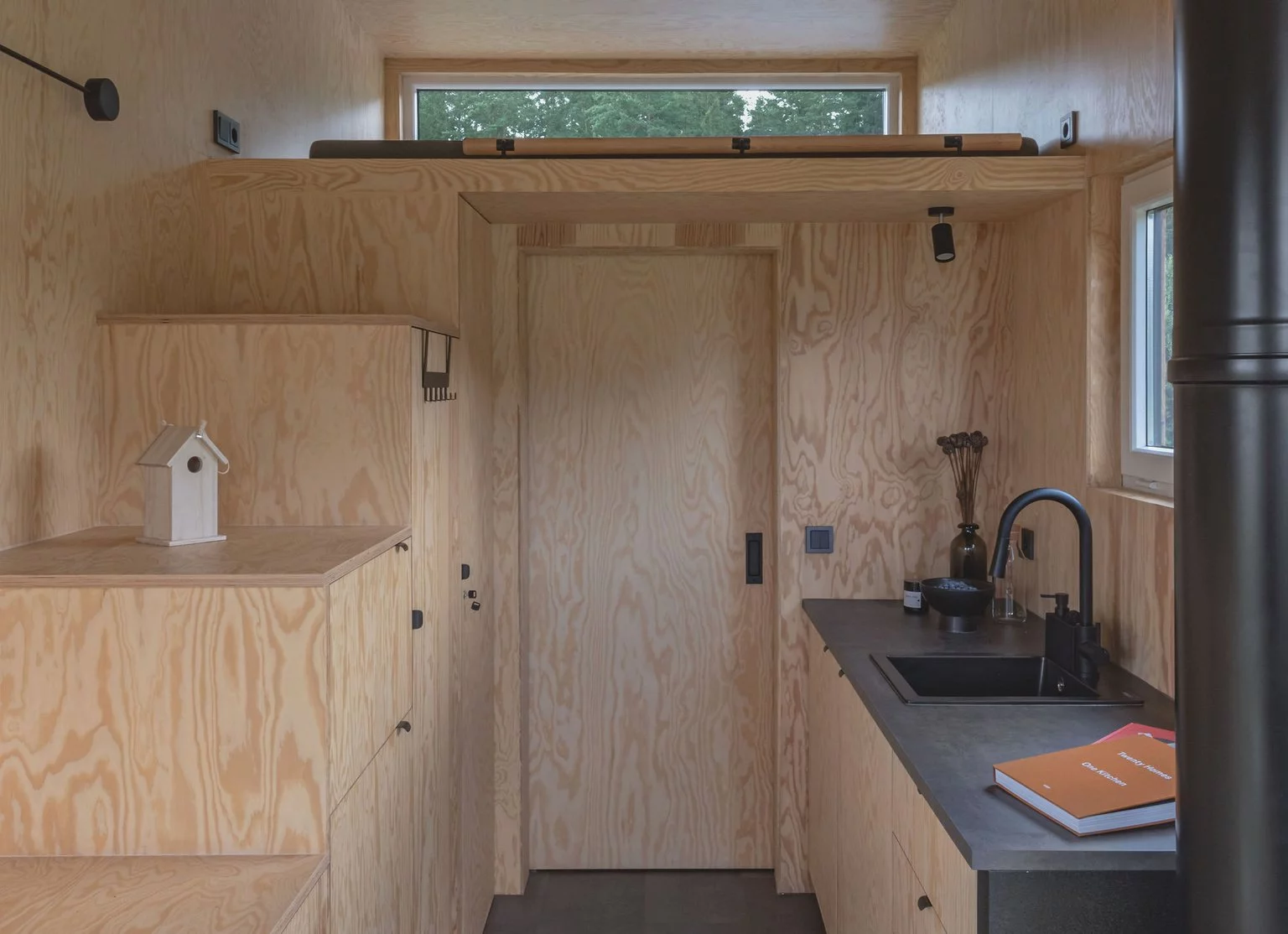 The BTH Loft off-grid's upstairs bedroom is reached by storage-integrated staircase