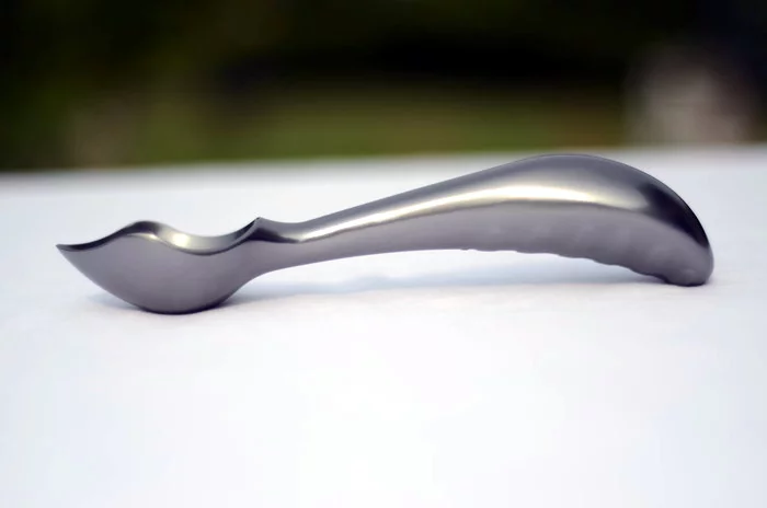 The Midnight Scoop is designed with a thick, curved handle that allows the user to push it through ice cream with their palm