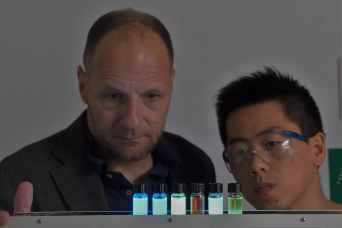 Prof. Uwe Bunz (left) and doctoral student Jinsong Han, with a selection of glowing polymer dyes