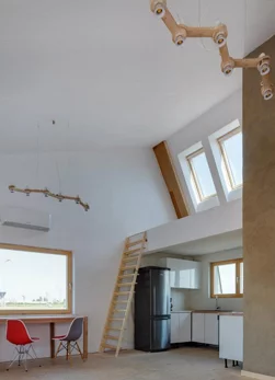 The home’s high ceilings offer impressive interior dimensions and facilitate the use of an elevated zone positioned above the kitchen