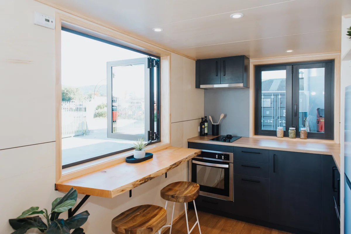 Scotty The Tiny House's kitchen includes a seating area for two with bifold windows. The kitchen benches are slightly higher than you might find in other builds, to suit the owners (who happen to be quite tall)