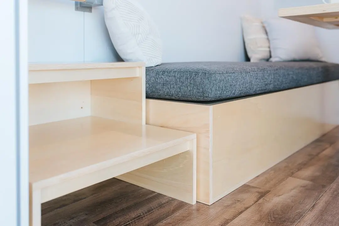 The Larissa and Tyler Tiny House's living room includes a sofa with integrated storage