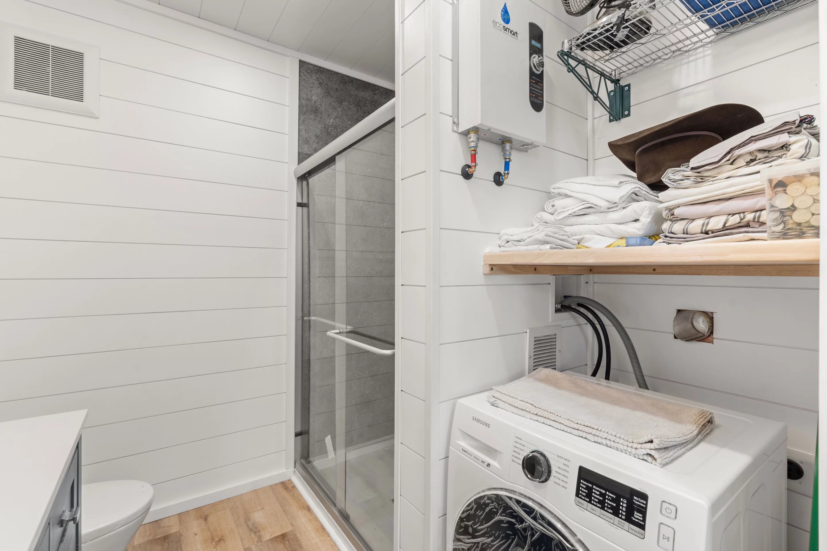 The Luke's bathroom includes a shower, vanity sink, flushing toilet, and a washer/dryer