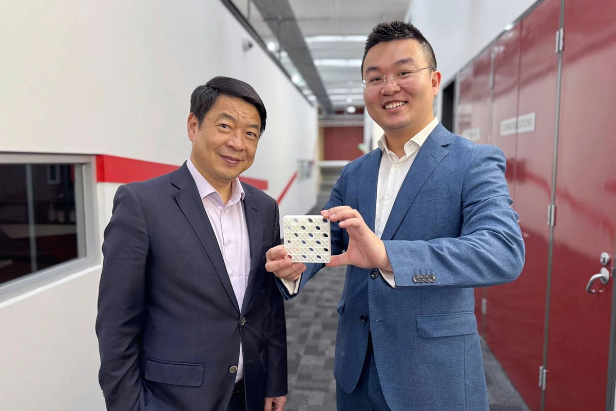 Researchers Mike Xie (left) and Dr. Jiaming Ma (right) hold a 3D-printed model of the team's double lattice design