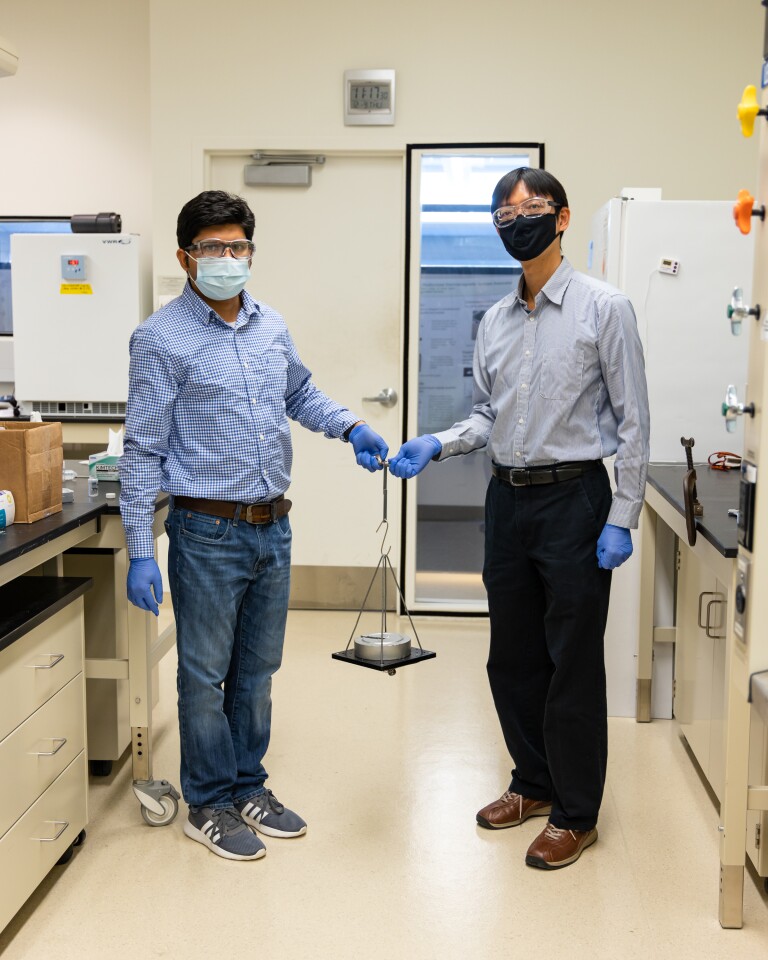 Study authors Anisur Rahman, left, and Tomonori Saito demonstrate the strength of their newly developed adhesive