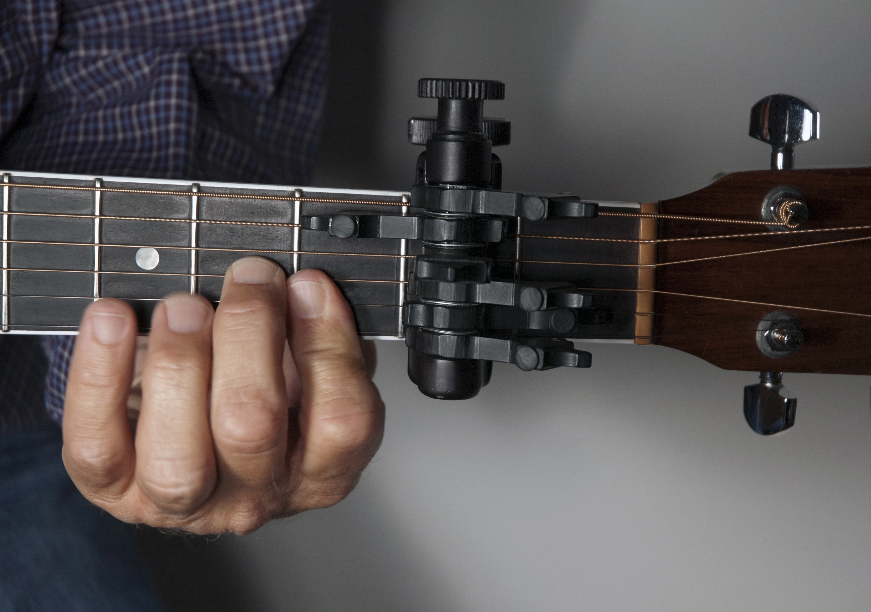 The CapoSonic works like a “clamped-on chord," allowing your guitar to stay in standard tuning