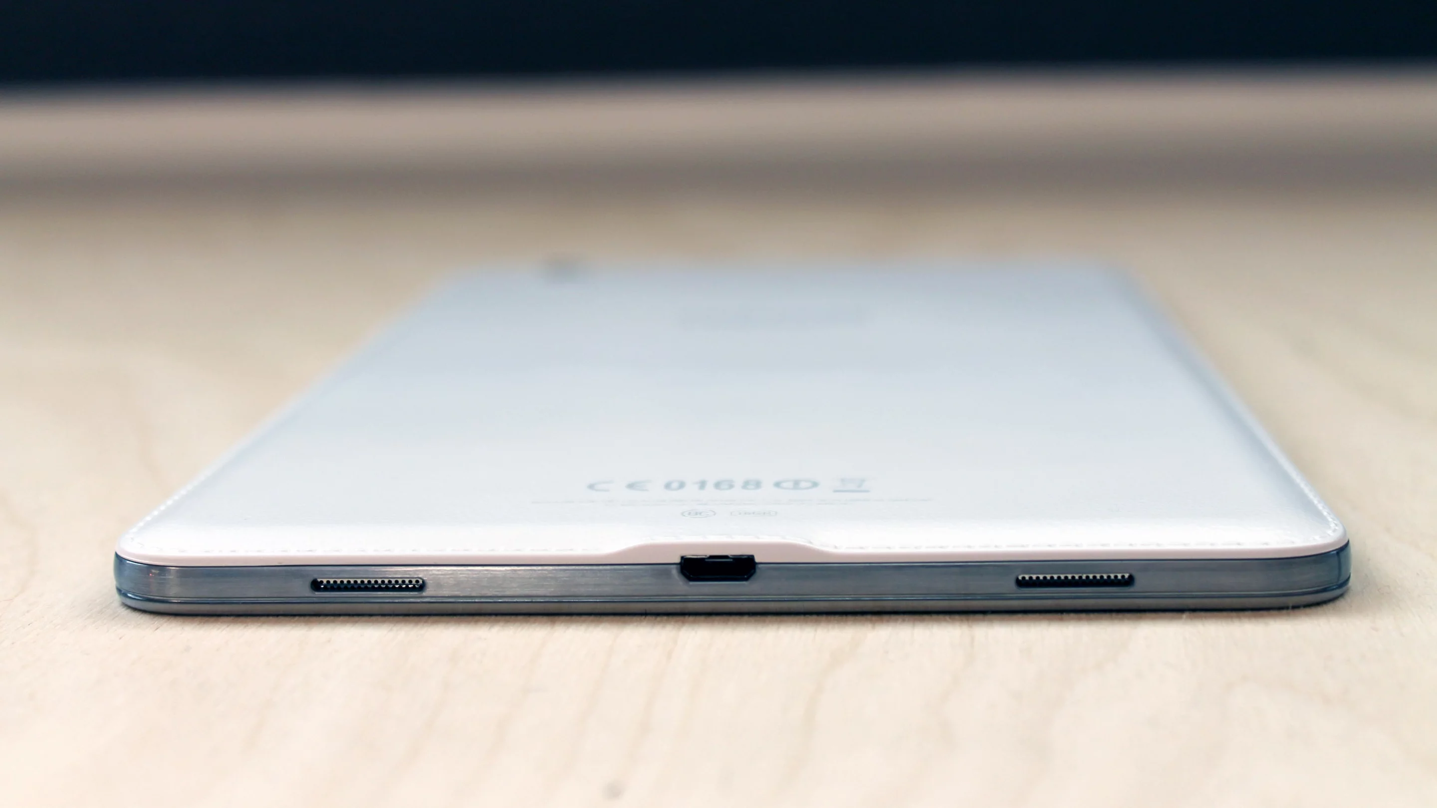 It has a metallic-looking plastic around the edge, and charges via microUSB