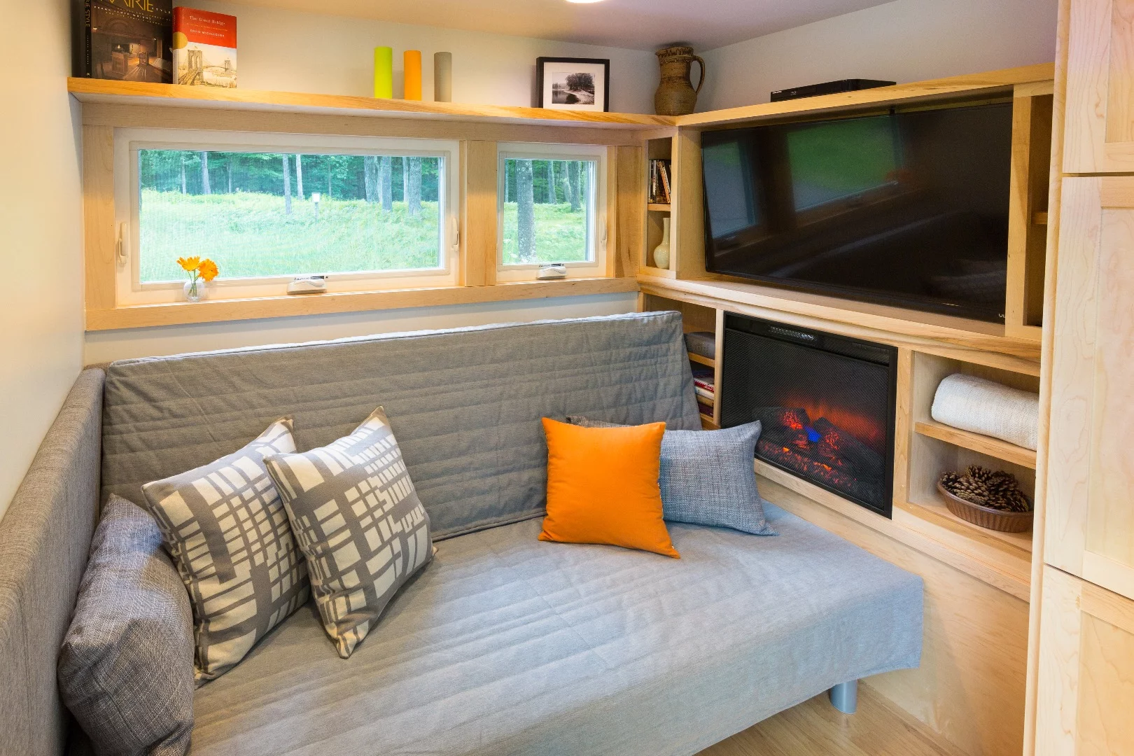 The lounge includes a sofa bed, television, and electric fireplace