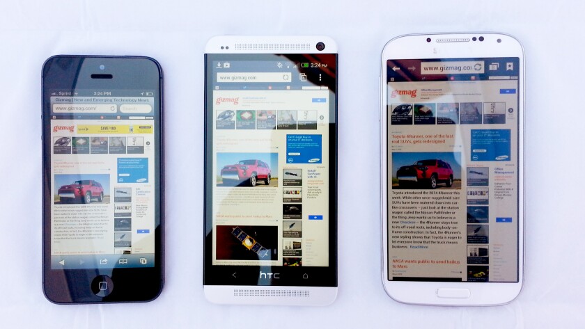 The One (center) next to the iPhone 5 and Galaxy S4