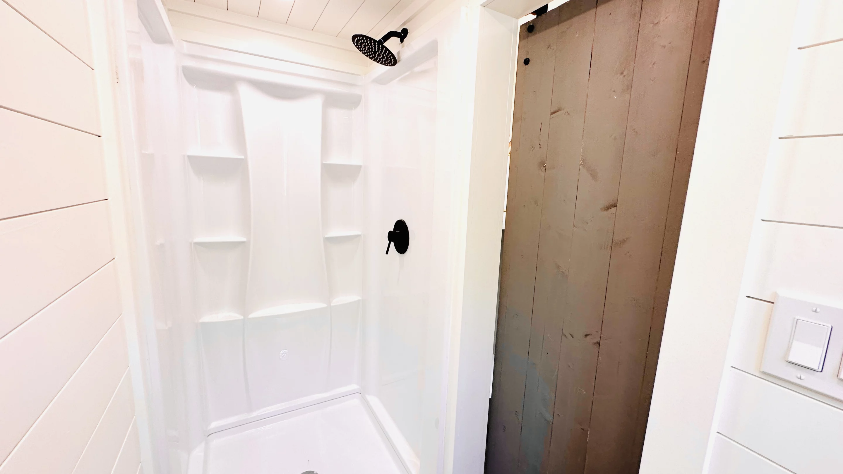 The 16' THOW With Loft's bathroom includes a shower and flushing toilet