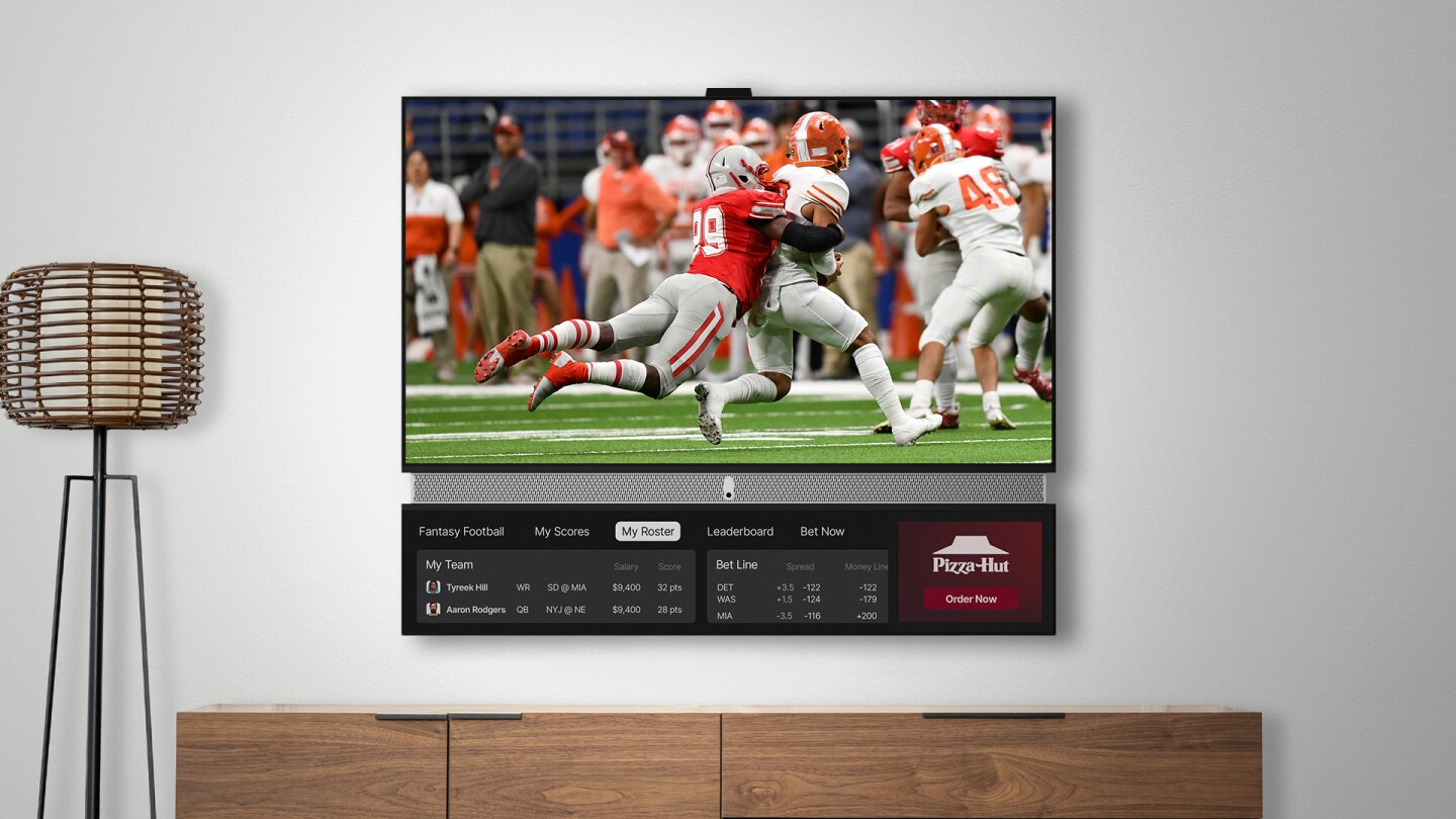 The idea is that while folks watch the main 55-inch 4K HDR TV screen, adverts and news/weather widgets appear on the smart display below, with audio coming from a Harman Kardon soundbar in the middle