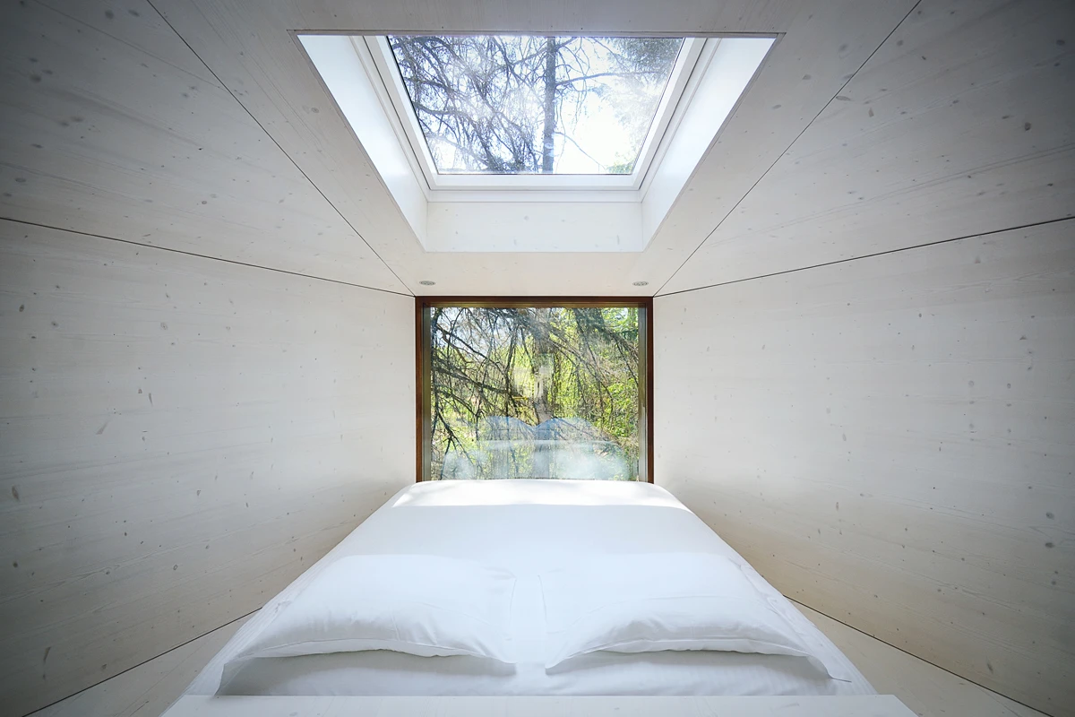 The bed is centrally positioned underneath a large skylight, most likely envisaged for for star gazing