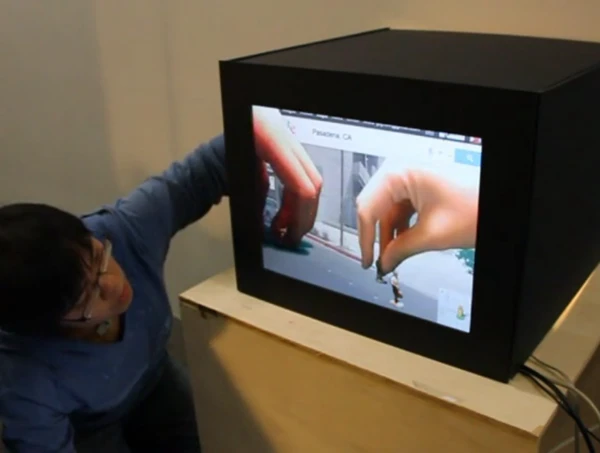 With Portal boxes, two people connected to the internet can literally reach behind a video screen to interact with the virtual world inside together