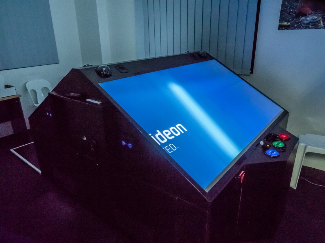 Without the glasses, there's little special to look at with these hologram arcade tables. They're big boxes with two slanted screens on them.