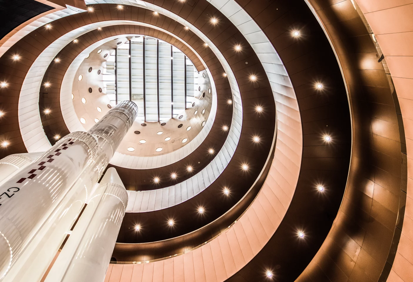 The interior of the building is centered around a huge central cone that offers access to the entire museum and includes a rocket