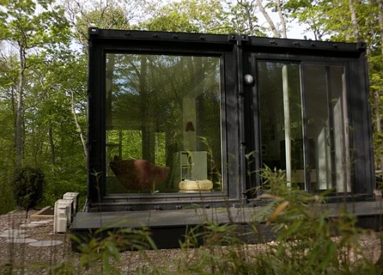The Container Studio sees the clever use of two standard shipping containers perched over a 9 foot (2.7 meter) foundation wall/cellar
