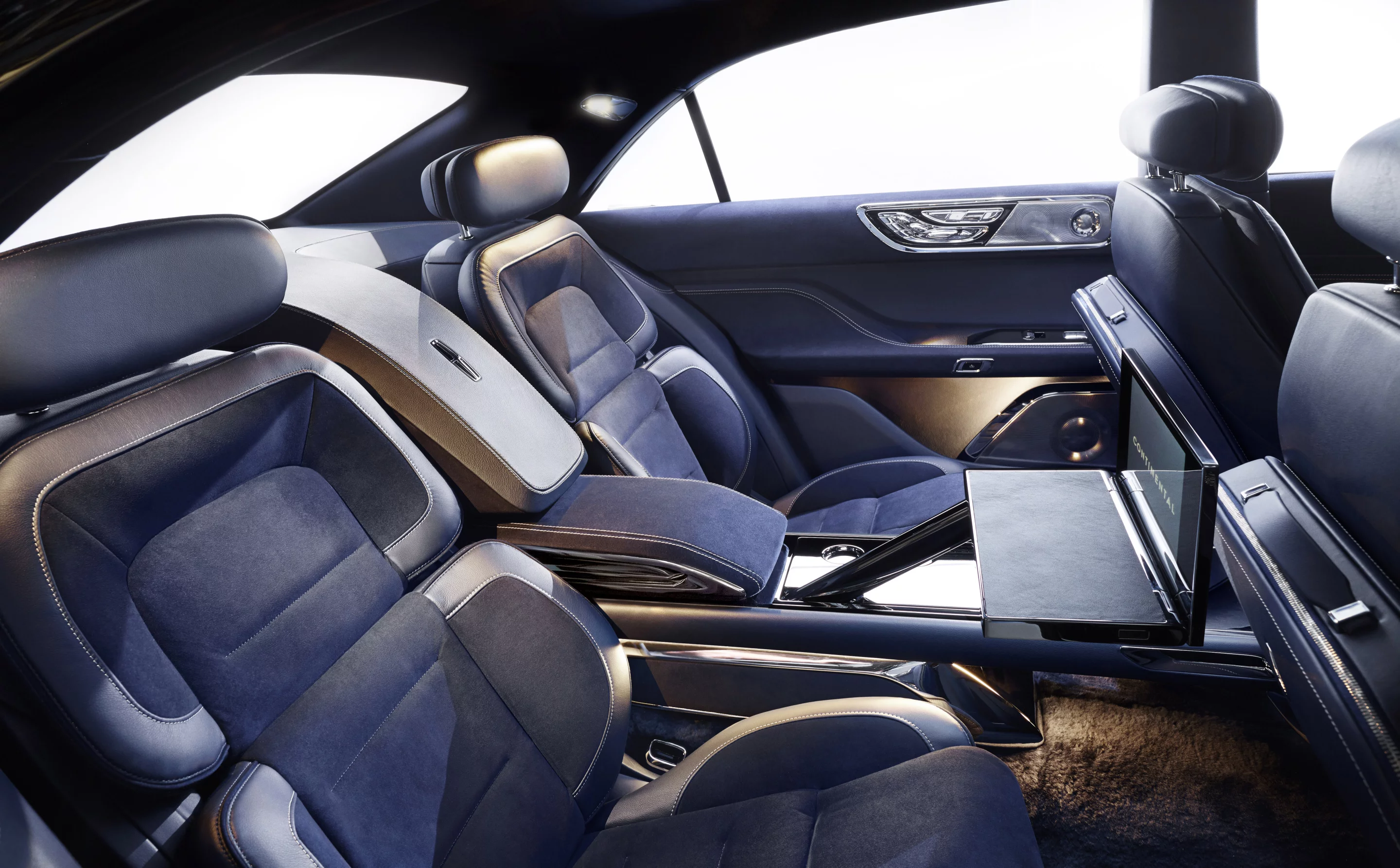 The rear passenger area includes a slide-out tablet tray for entertainment and productivity