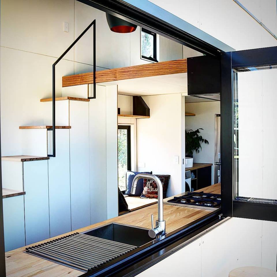 Gorgeous minimal kitchen opens up onto the Sowelo tiny home's external decking