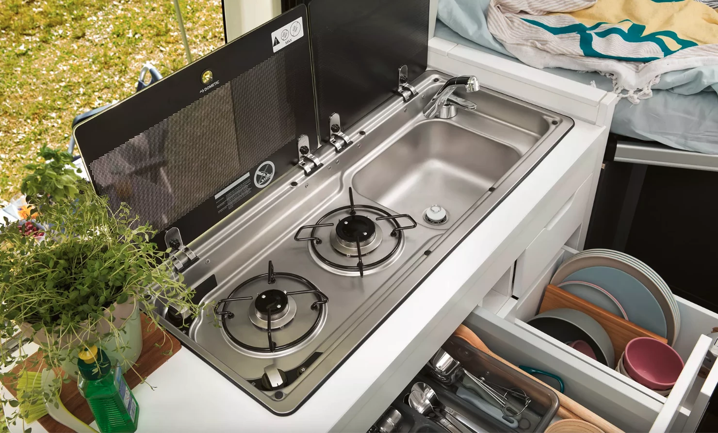 No retractable stove burners like on the California XXL concept; the Grand California kitchen block includes a typical dual-burner stove/sink combo