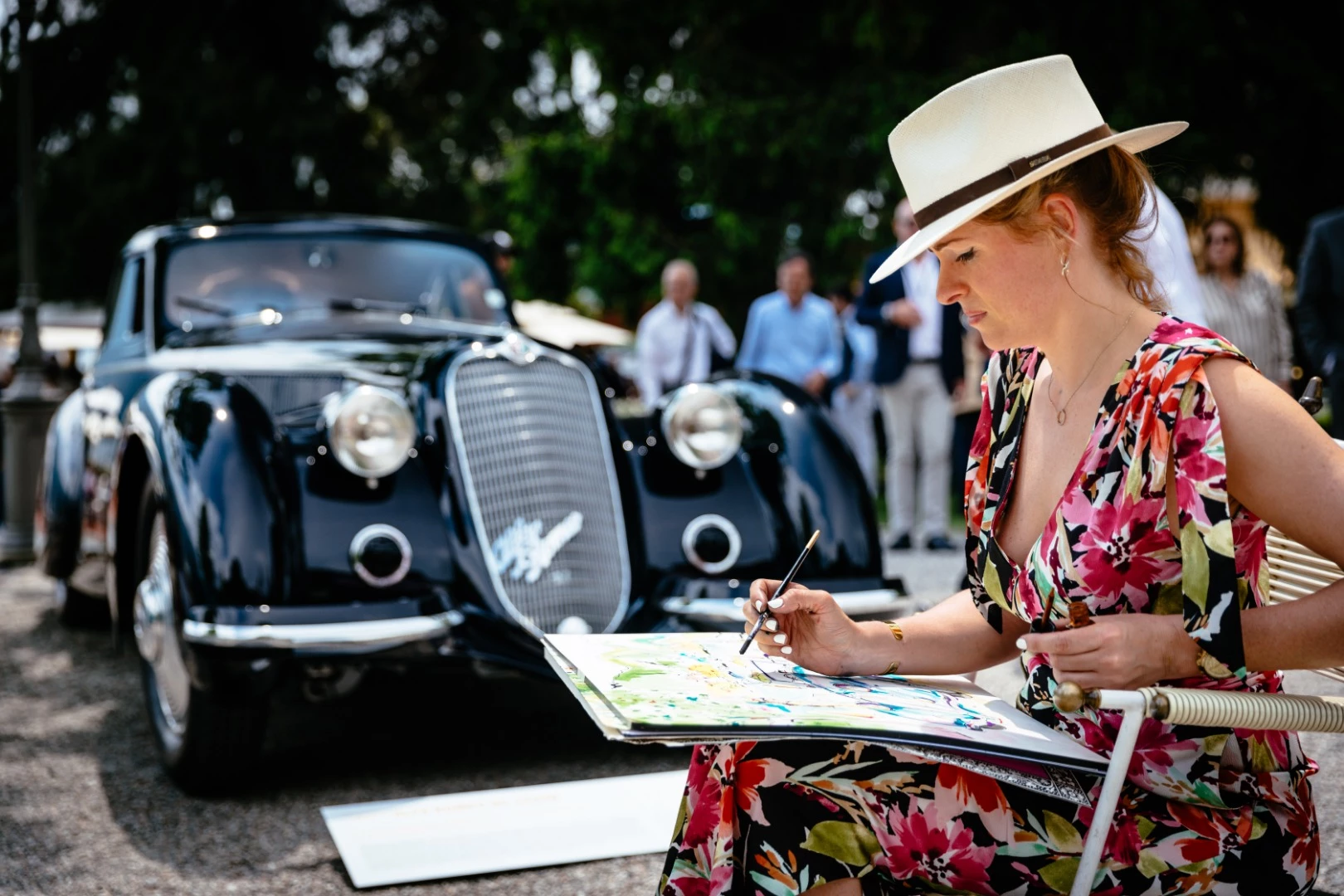 A sketch artist capturing the beauty of the 1937 Alfa Romeo 8C 2900B Touring Berlinetta at Villa d’Este