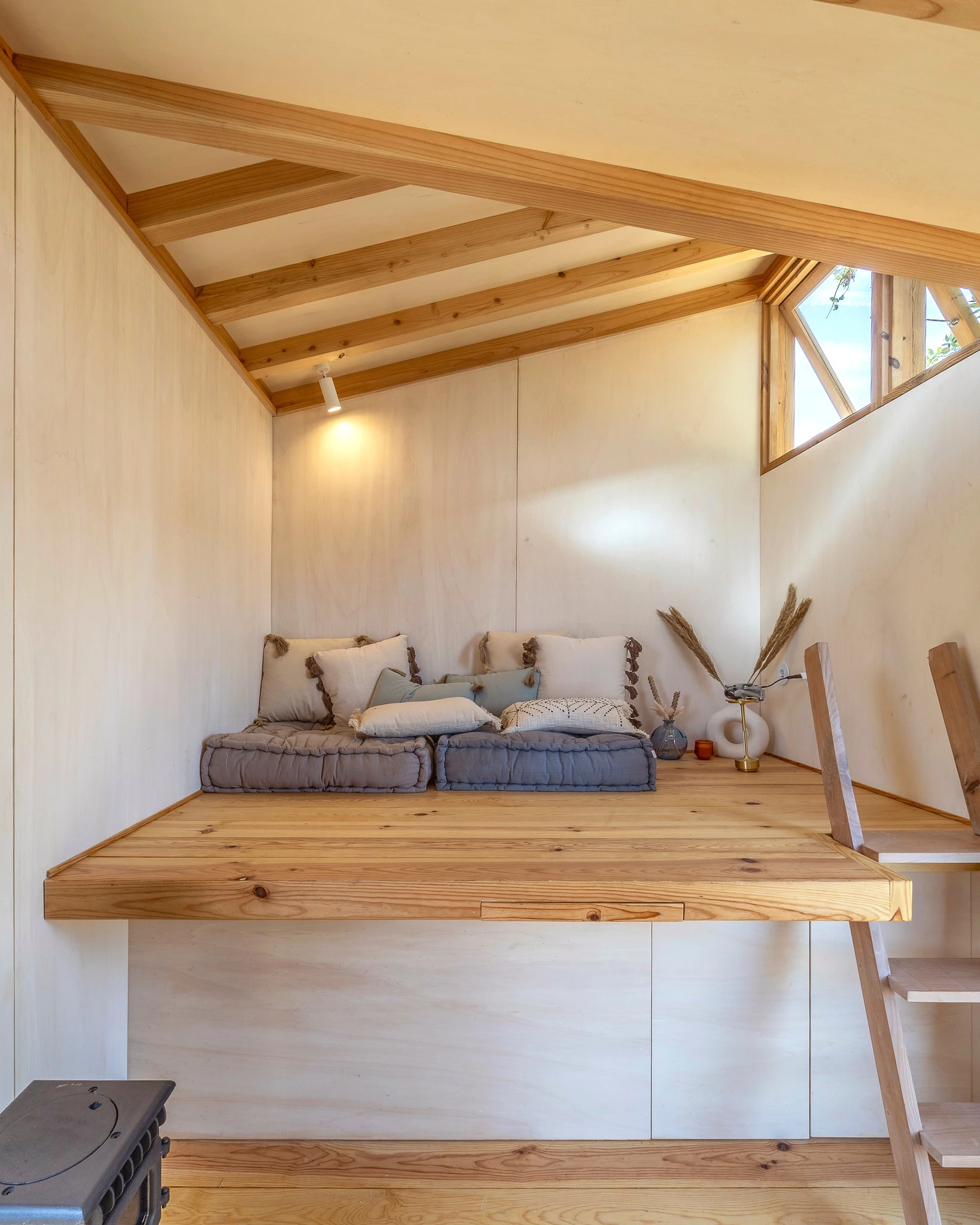 The Terra m3_Tiny House features a raised living room that's reached by a few wooden steps