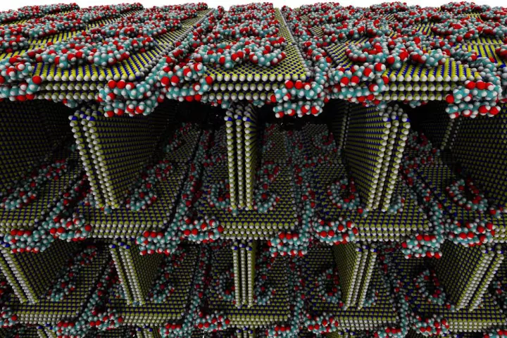 This simulated image shows the structure of the foam, with sheets of hexagonal-boron nitride (blue and yellow), with PVA molecules holding carbon (teal), oxygen (red) and hydrogen (white)