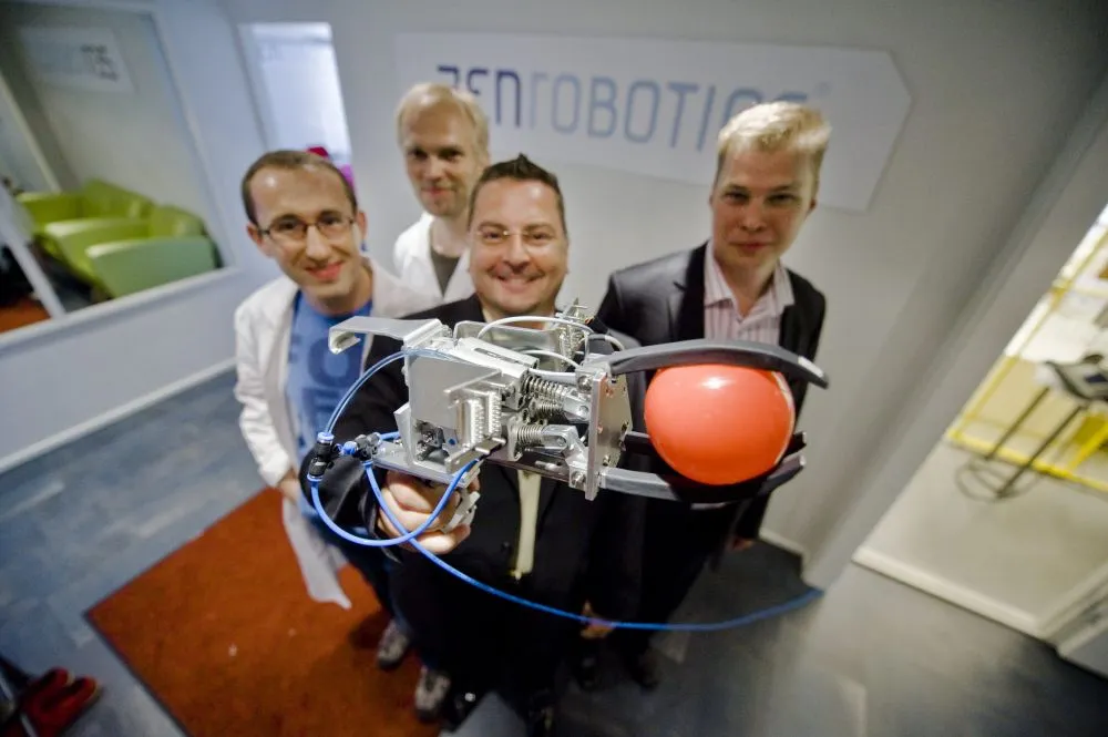 ZenRobotics staff, with the Recycler robot's picking hand(All images courtesy ZenRobotics)