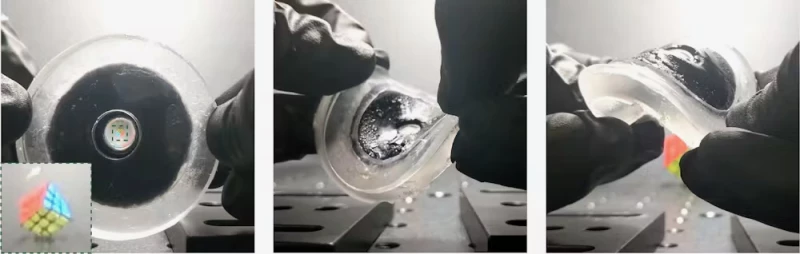 Secuencia de tres fotografías que muestran un disco transparente con un núcleo oscuro y un pequeño objeto holográfico en el centro. En cada imagen, unas manos con guantes negros doblan y comprimen el material para demostrar su flexibilidad, mientras el marcador multicolor permanece visible.