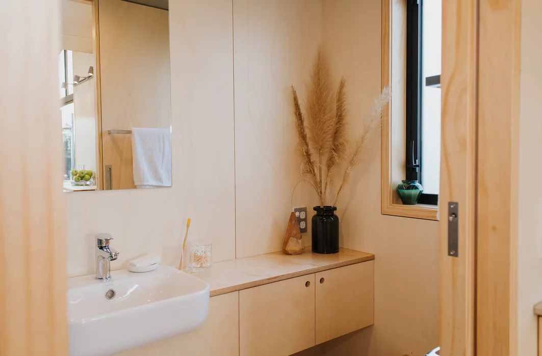 The First Light Tiny House bathroom includes vanity unit, shower, and composting toilet