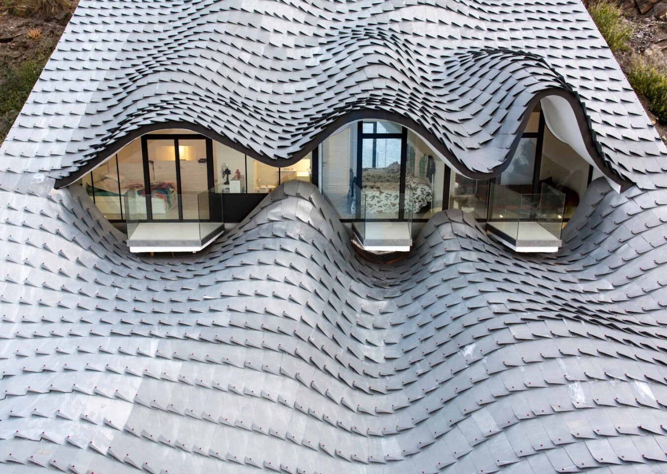 The home's defining roof lends the appearance of a scaled dragon looking out to sea