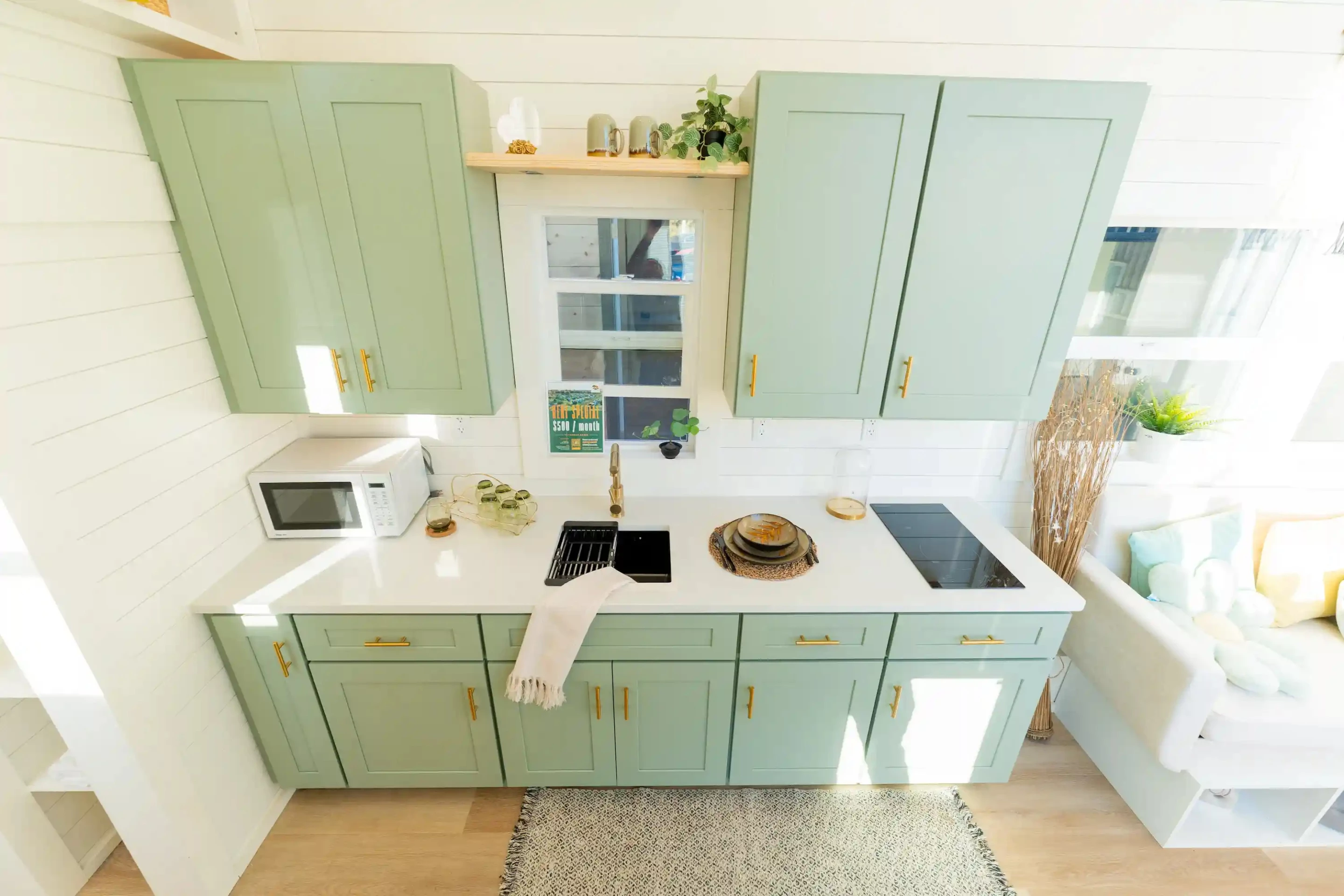 The kitchen in the Avalon 32' includes an induction cooktop, a sink, a fridge/freezer, and lots of cabinetry