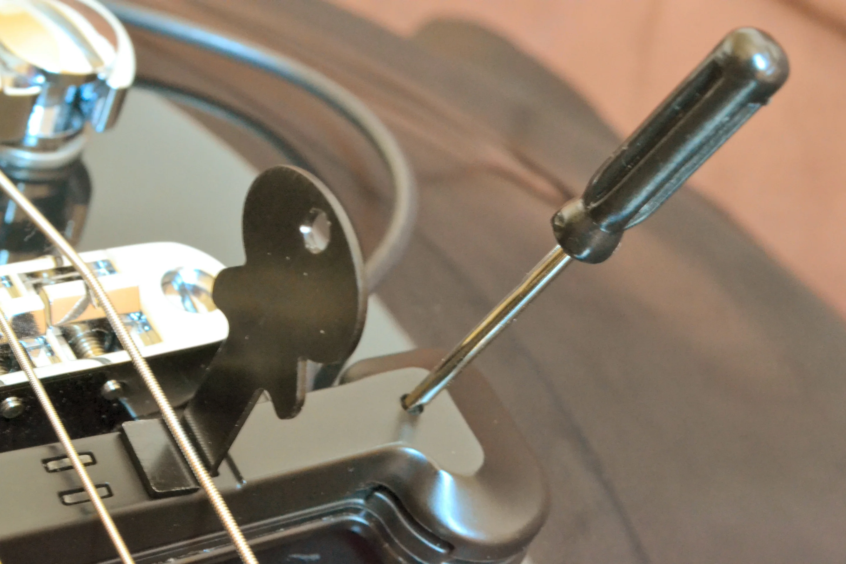 There's a little guitar-shaped metal spacer tool to help gauge the appropriate distance, and a tiny screwdriver for micro adjustments to the height of the pickup itself (Photo: Paul Ridden/Gizmag)