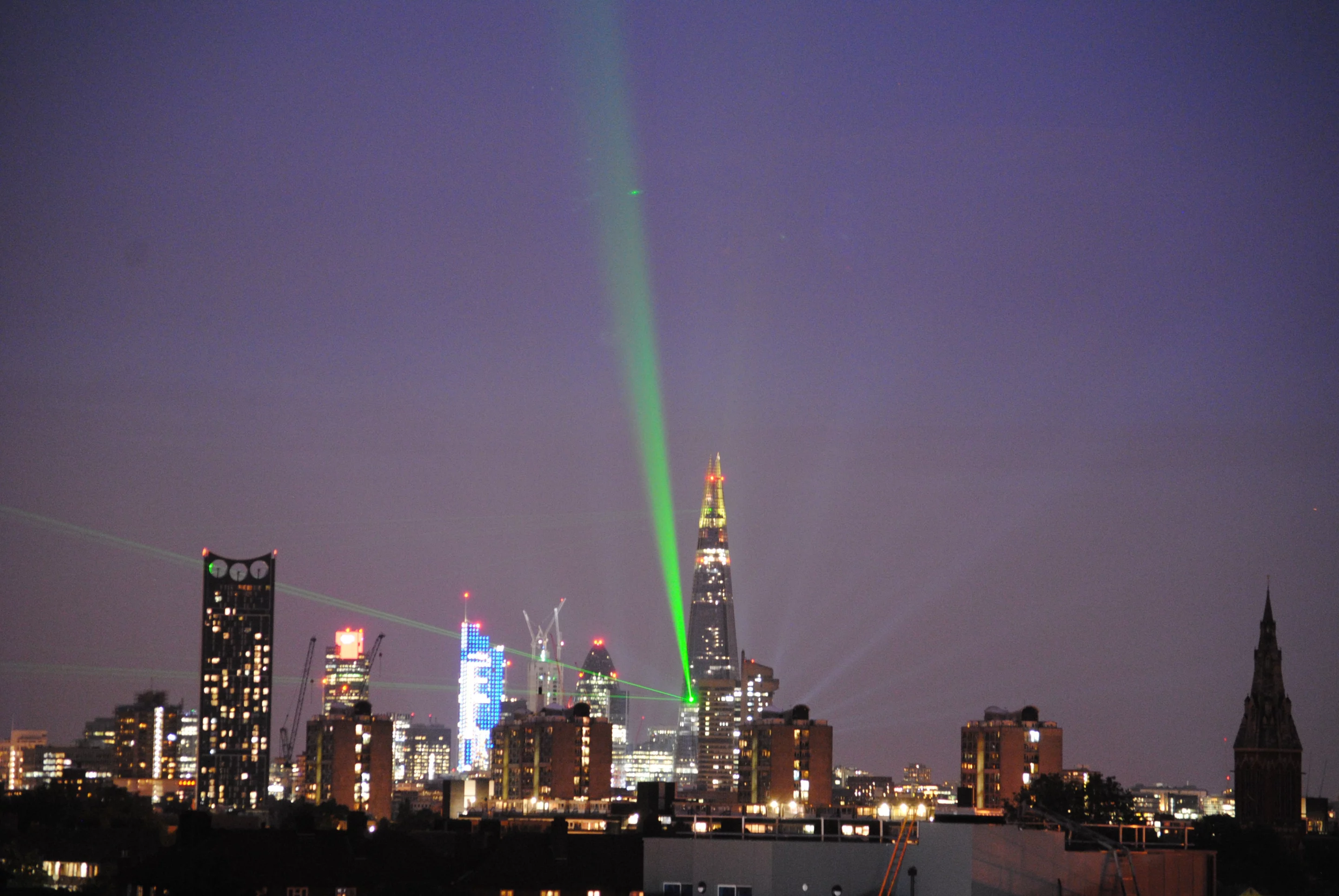 A dozen emerald-green laser beams emanated from the Shard to pick out iconic landmarks including the London Eye, St. Paul's Cathedral and Tower Bridge (1016-ft) Shard in London (Photo: Jenny Brown)