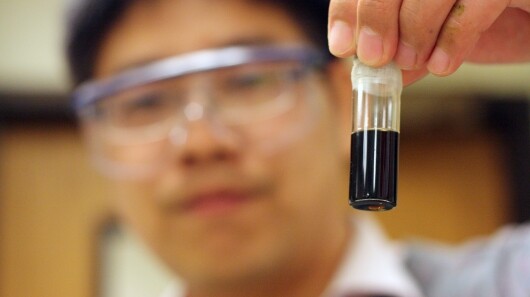 Peigao Duan, a University of Michigan graduate student, holds a vial of bio-oil created from algae
