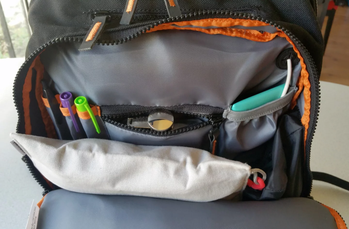 The MOS Pack's front compartment unzips half-panel, offering pockets to store pens and smaller items
