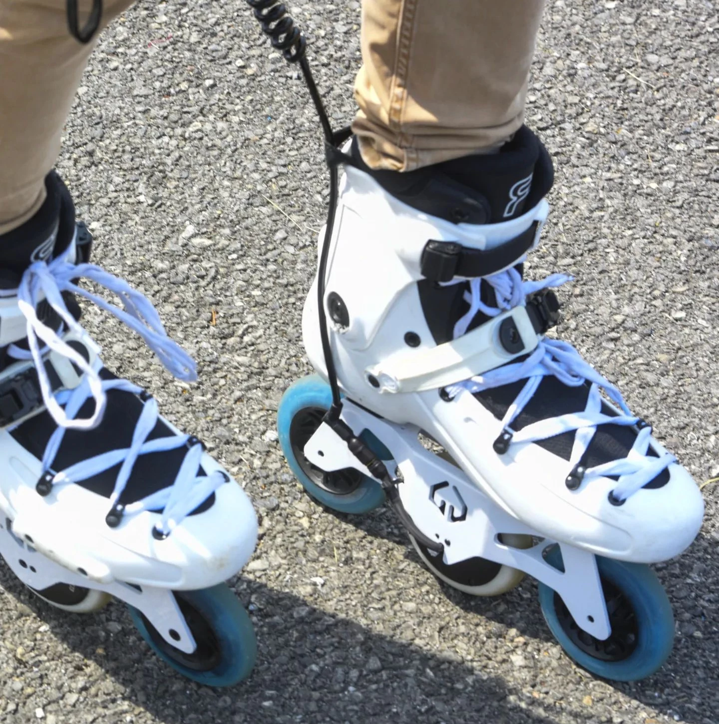 The battery is hard-wired to each skate via a curly cord