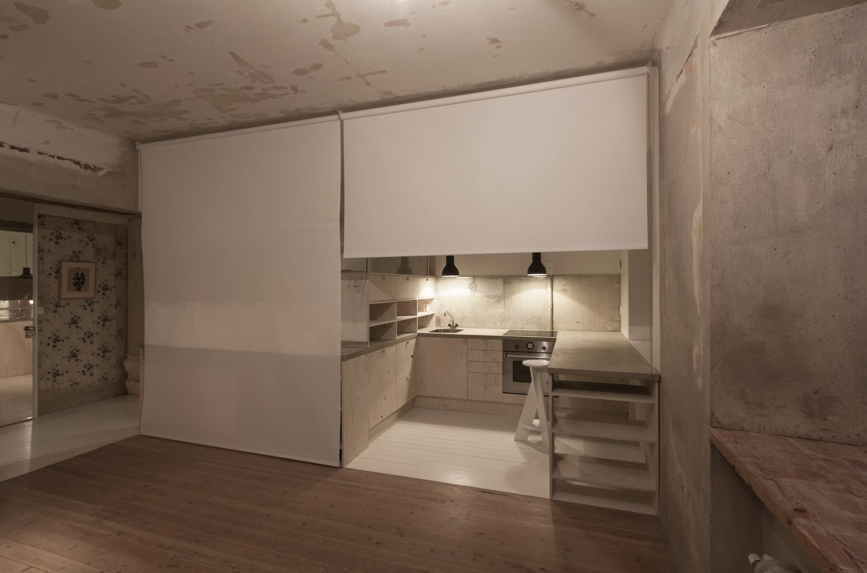 Roller curtains have been fitted to the ceiling, allowing the kitchen and/or the sleeping quarters to be closed off from the living area