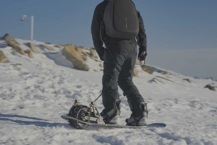 The Cyrusher Ripple uses a battery backpack and handheld controller to motor its way across snow - whether downhill, flat or uphill