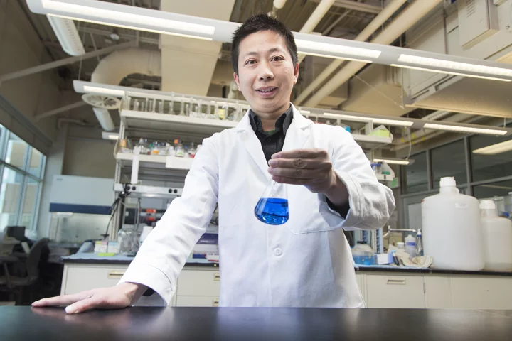 Lead scientist Dr. Jixun Zhan, with a flask of indigoidine
