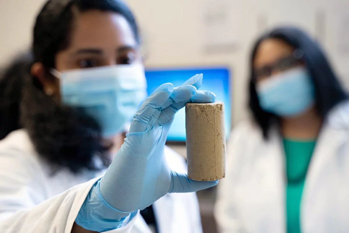 Study author Chinchu Cherian with a sample of the cement incorporating recycled pulp mill fly ash