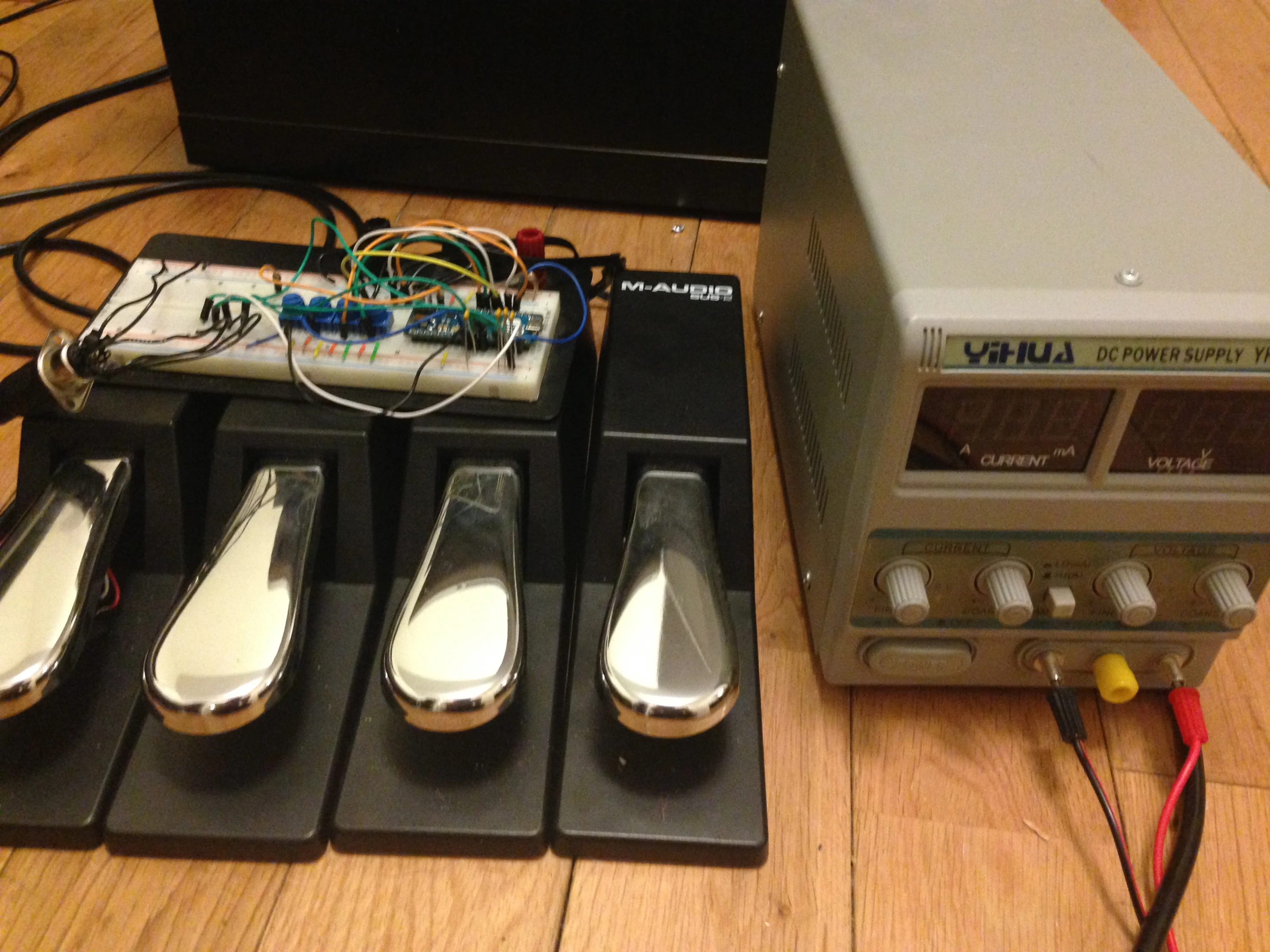 The circuitry of a keyboard sustain pedal was stripped out and replaced with a magnet and a continuous ratiometric hall effect sensor for smooth bend control