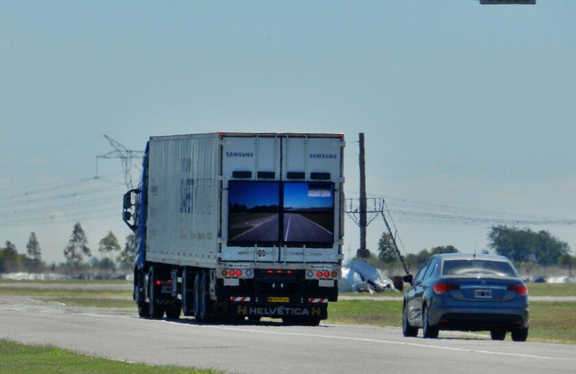 With a front-mounted camera, the system captures the view of the road in front of the truck and streams it to a large display on the back, made up of four weatherproof monitors