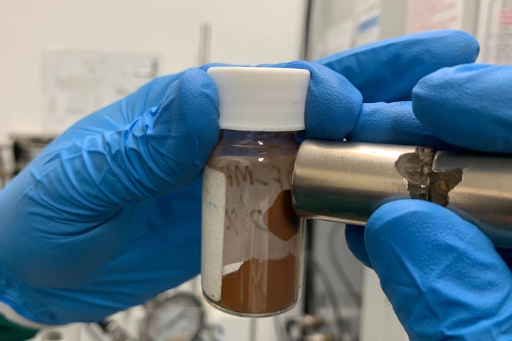 A magnet attracts microplastic particles that have been adsorbed by the ferromagnetic powder