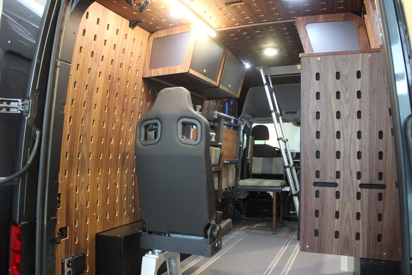 Austria's Autocom Rental & Trading GmbH designed the Cargo Camper Mountain 4x4 MAN TGE, a rugged, versatile adventure van that uses a modular camping furniture system with pegboard-style walls and ceiling