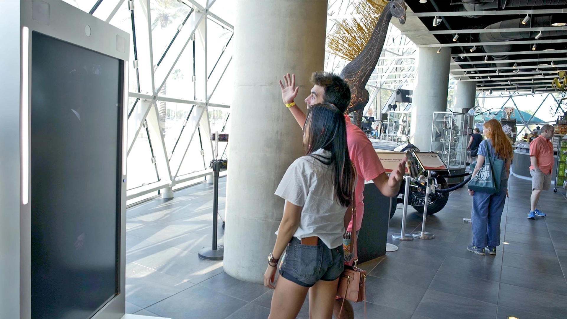As museum patrons exit the exhibition Dali catches them to say goodbye and take a selfie